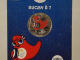 a close up of a coin with a red bird on it