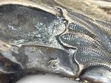 a close up of a silver plate with a fish on it