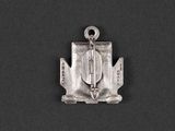 a small silver pendant with a cross on top of it