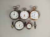 plusieurs types de montres de poche sont exposés sur une table