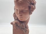 sculpture représentant la tête d'une femme sur une surface blanche