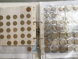 un classeur rempli de pièces de monnaie posé sur une table