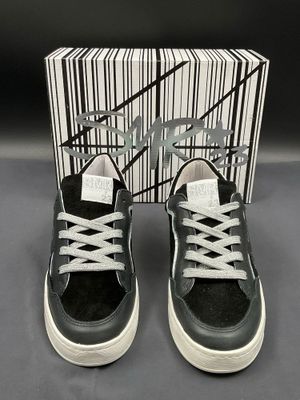 black and white sneakers with white laces and a box of black and white shoes