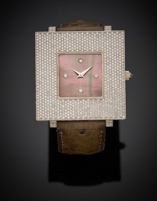 a close up of a watch on a black surface with a black background