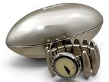 a silver watch sitting on top of a football shaped object