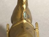 brass statue of a horse with a bell on a stand