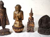 quatre statues de bouddhas assis les uns à côté des autres