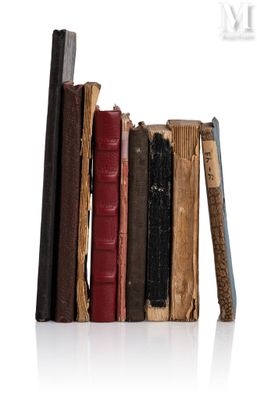 une pile de vieux livres posée sur une surface blanche