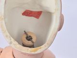 a small doll that has a button in it ' s mouth