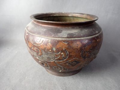 un pot marron orné d'un motif, posé sur une table
