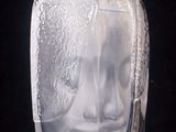 a glass vase with a face on it on a table