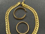 a close up of two rings and a necklace on a table