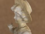a small statue of a boy with a hat on his head