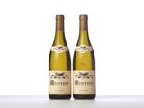 two bottles of white wine sitting on top of a table