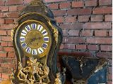a clock that is sitting on a table next to a brick wall