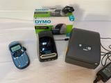 three cell phones sitting next to a printer and a cell phone