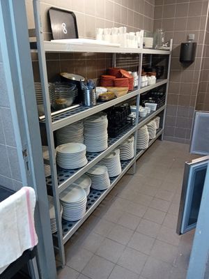 beaucoup d'assiettes et de bols sur les étagères de la cuisine