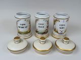 three white and gold vases sitting on top of a white table