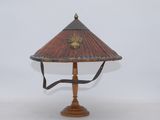 a wooden table lamp with a red shade on top of it