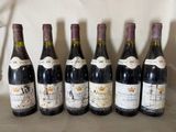 six bottles of wine are lined up in a row on a table