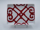 assiette rouge et blanche ornée d'un motif, posée sur un support métallique