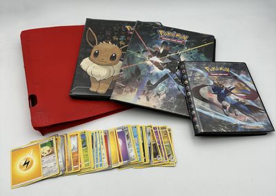 beaucoup de cartes pokemon et un livre sur la table