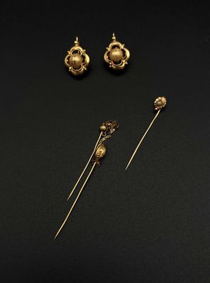 trois boucles d'oreilles en or et une paire de boucles d'oreilles posées sur un fond noir
