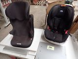two baby seats sitting on top of a white table