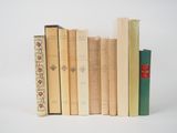 plusieurs vieux livres sont empilés sur une surface blanche