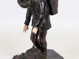 figurine of a man with a backpack on a rock