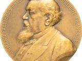 an image of a gold medal with a portrait of a man with a beard