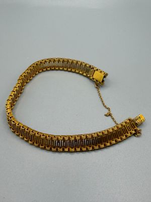 a close up of a gold bracelet on a table