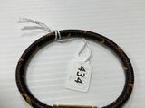un gros plan d'un bracelet posé sur une table, avec une étiquette de prix