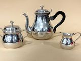 une théière en argent et une cafetière en argent posées sur une table