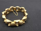 a close up of a gold bracelet on a black surface