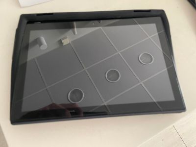 une tablette posée sur une table, à côté d'une tasse de café