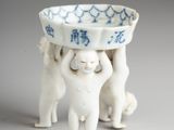 two cats holding a bowl on top of each other