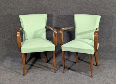 pair of green upholstered chairs against a gray background