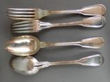 quatre cuillères en argent et deux cuillères en argent sur une table