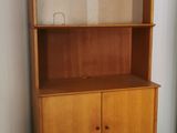 a wooden bookcase with two drawers in the corner of the room