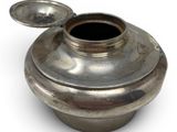 a silver vase with a lid on a white surface