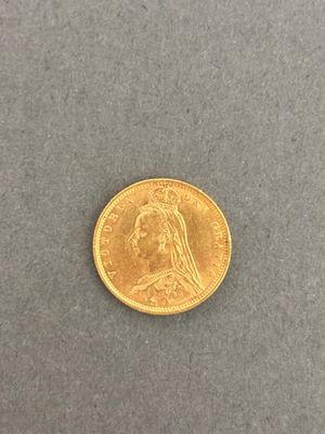 a close up of a gold coin on a gray surface