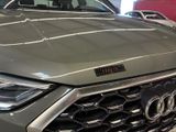 the front end of a grey audi suv parked in a showroom
