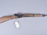 an old rifle with a wooden handle and a tag on it