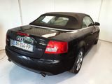 a black car parked in a garage with its roof down