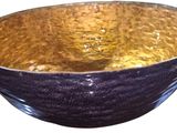 a black and gold bowl sitting on a white surface