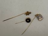 two pairs of gold earrings with black and white stones on them