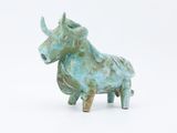 a small statue of a bull on a white surface