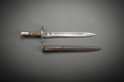 a close up of a knife on a table next to a knife on a table