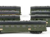 three green train cars sitting next to each other on a white surface